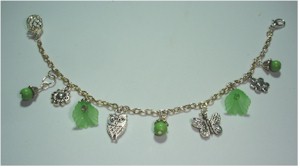 Silver charms and green flowers on silver link bracelet.