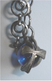 Pewter crosses encircle iridescent blue globe pendant.