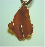 Copper wire wrapped amber sea glass with crystal on suede cord necklace.