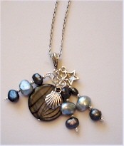 Mother of Pearl disk, freshwater pearls and silver charms on silver chain necklace.