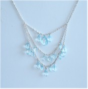 Pale blue crystals dangle from 3 rows of silver chains.