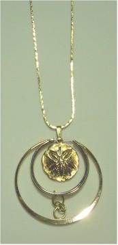 Vintage Gold Napier Sand Dollar encircled by two gold rings on gold chain.